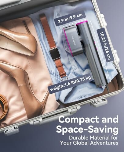 Compact cordless vacuum packed in a suitcase with clothes and shoes.