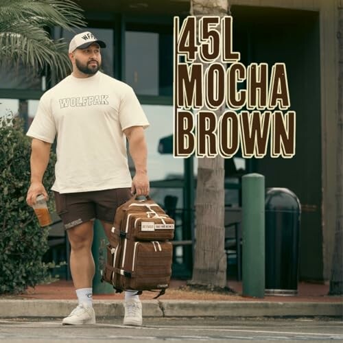 Man holding a drink and a large brown backpack outside.