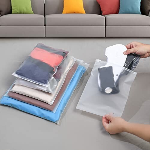 Hands using vacuum seal bags for clothes storage on a floor.