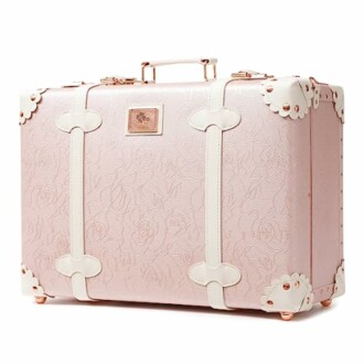 Vintage-style pink suitcase with white straps and floral pattern