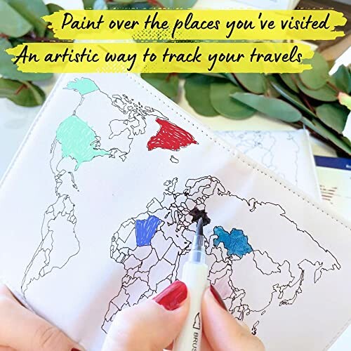 Person coloring a world map to track visited countries.